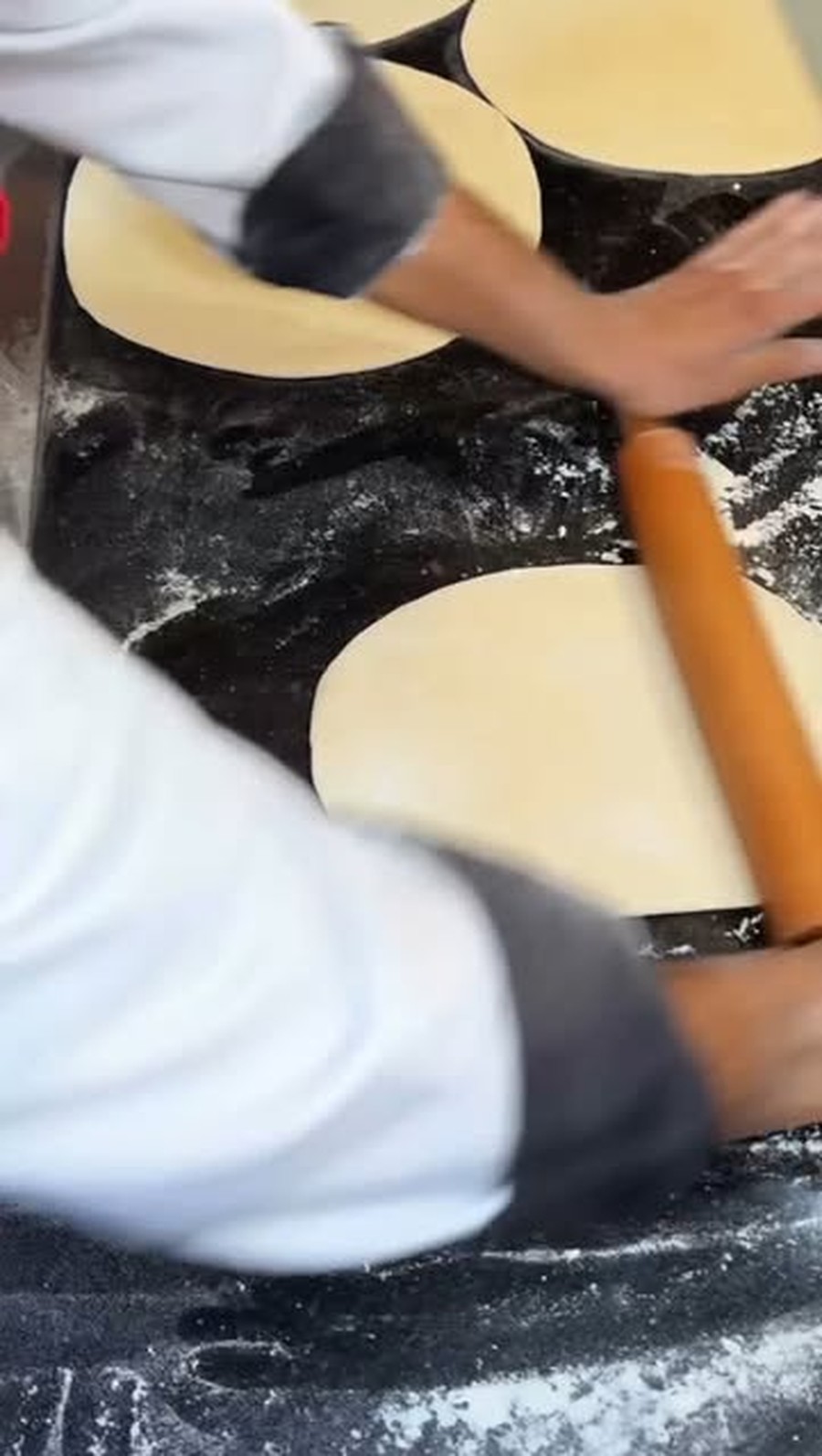 A Fornello baker rolling fresh pizza dough