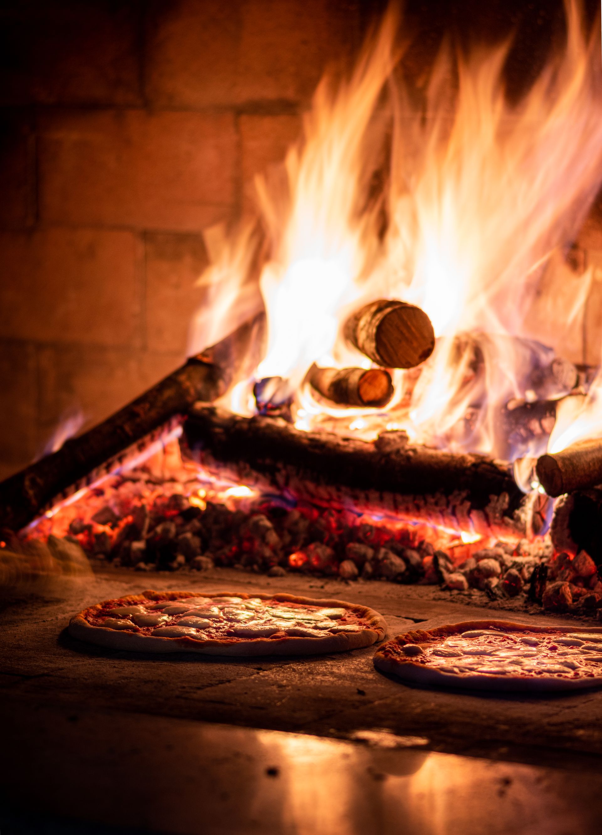Pizza baking in a wood-fired stone oven